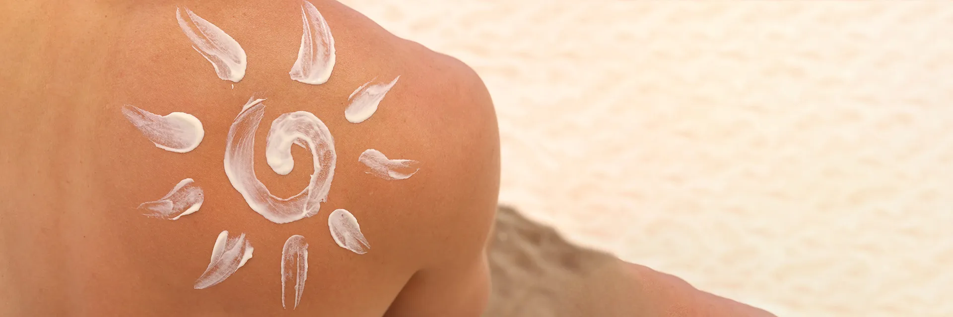 Sunscreen for men applied as a sun shape on a man’s shoulder at the beach